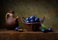 Still life with black plums in a basket Royalty Free Stock Photo