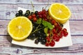 Still life black, red currant and two halves of lemon Royalty Free Stock Photo