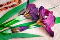 Still life: Blossoming irises and costume jewelry against a table.