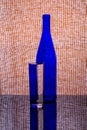 Still life with a blue bottle and a glass of water Royalty Free Stock Photo