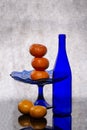 Still life with a blue bottle and tangerines Royalty Free Stock Photo