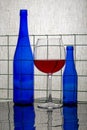 Still life with blue bottles and a glass of red wine Royalty Free Stock Photo