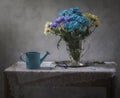 Still life with blue watering can and a bouquet of chrysanthemums