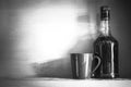 Still life of bottle of alcohol with cup on a shelve, vintage filterd