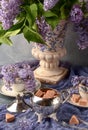 Still life with a bouquet of blooming lilacs and silverware, antique vase Royalty Free Stock Photo