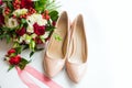 Still life from a bouquet of flowers and the bride`s shoes on a white background Royalty Free Stock Photo
