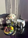 Still life with a bouquet of light pink roses, a plate of fruit, glasses and champagne on ice. The concept of setting a