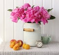 Still life with a bouquet of pink peonies, peaches and apricots