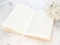 Still life, a bouquet of white flowers and a notebook on a light wooden background, space for text Royalty Free Stock Photo