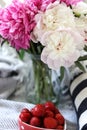 a still life with a bouquet of white and pink peonies and strawberries Royalty Free Stock Photo