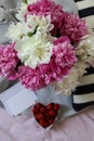 a still life with a bouquet of white and pink peonies, strawberries and a blank message card Royalty Free Stock Photo