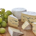 Still life of brie cheese and grapes on a wooden board isolated on a white background. Side view Royalty Free Stock Photo