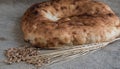 Wheat ears and pita bread with wheat grains lie on burlap