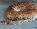 Wheat ears and pita bread with wheat grains lie on burlap