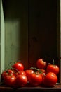 Still Life with a bunch of natural grown Tomatoes. Rustic wood background, antique wooden table Royalty Free Stock Photo