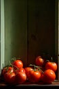 Still Life with a bunch of natural grown Tomatoes. Rustic wood background, antique wooden table Royalty Free Stock Photo