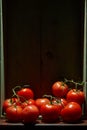 Still Life with a bunch of natural grown Tomatoes. Rustic wood background, antique wooden table Royalty Free Stock Photo