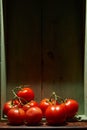 Still Life with a bunch of natural grown Tomatoes. Rustic wood background, antique wooden table Royalty Free Stock Photo