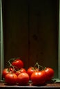 Still Life with a bunch of natural grown Tomatoes. Rustic wood background, antique wooden table Royalty Free Stock Photo