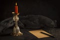 Still life, burning candle on a gadget and a sheet of old paper with a pencil Royalty Free Stock Photo