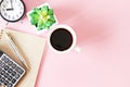 Top view or flat lay of notebook paper with pen, calculator, clock and coffee cup on pink background, ready for adding or mock up Royalty Free Stock Photo