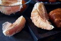 Still life of carelessly scattered grapefruit slices and pomelo at grey background