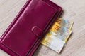 Still life of cash. Bordeaux leather wallet and Swiss francs on a wooden background Royalty Free Stock Photo