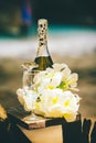 still life of champagne tropical flowers stemware and bridal rings