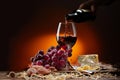 Wine is poured from a bottle into a glass Still-life with cheese, grapes and glass and bottle of red wine Royalty Free Stock Photo