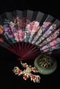 Still life in Chinese style. traditional hairpins, incense burner and fan isolated on black background Royalty Free Stock Photo