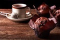 Still life with chocolate muffin and cup of tea on old wooden board table and with black background Royalty Free Stock Photo