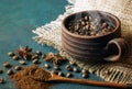 Still life with a clay cup filled with coffee beans,anise stars and wooden spoon Royalty Free Stock Photo