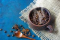 Still life with a clay cup filled with coffee beans,anise stars and wooden spoon Royalty Free Stock Photo