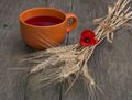 Still life a clay mug with juice, wheat and a flower of poppy Royalty Free Stock Photo