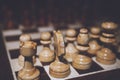 Still life close up detail view of a queen chess dark wooden piece on a chess board while a strategic game is being played. Interi