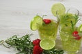 Still life with colorful bright cocktails on wooden background, decorated with rosemary, strawberry and lime Royalty Free Stock Photo