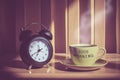 Still life of coffee cup and clack on table