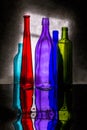 Still life with colored bottles on a reflective surface Royalty Free Stock Photo