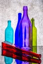 Still life with colored bottles on a reflective surface Royalty Free Stock Photo