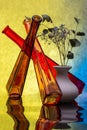 Still life with colored bottles and a vase of flowers Royalty Free Stock Photo