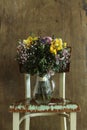 a still life with a colorful bouquet of flowers in a glass vase