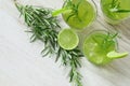 Still life with colorful bright cocktails on wooden background, decorated with rosemary and lime Royalty Free Stock Photo