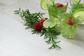 Still life with colorful bright cocktails on wooden background, decorated with rosemary, strawberry and lime Royalty Free Stock Photo