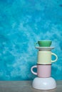 colorful ceramic bowls and coffee cups and teapot on a table against blue background. space for text Royalty Free Stock Photo