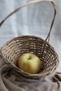 Still life composition of an apple in a wicker basket Royalty Free Stock Photo