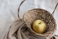 Still life composition of an apple in a wicker basket Royalty Free Stock Photo