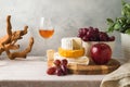 Still life composition with cheese, grapes, nuts and wine glass on table Royalty Free Stock Photo