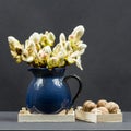 Still life composition with chestnut buds, flowers and small leaves in a blue ceramic pot and walnuts Royalty Free Stock Photo