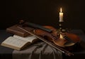 A still life composition featuring a violin resting on a dark fabric-covered table. The Royalty Free Stock Photo