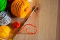 Still life with a crochet hook and red thread and yarn for knitting on wooden background Royalty Free Stock Photo